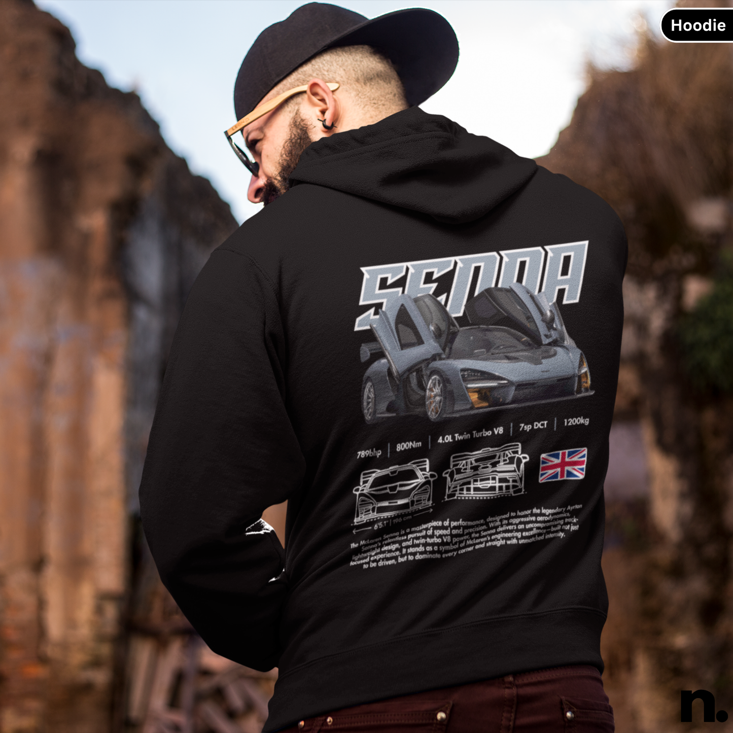 Person wearing a black hoodie with a car design and 'Senna' branding on the back, standing outdoors.