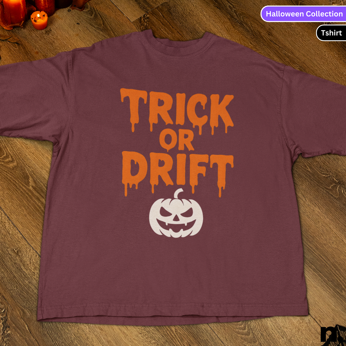 Purple t-shirt with 'Trick or Drift' text and pumpkin graphic on a wooden surface