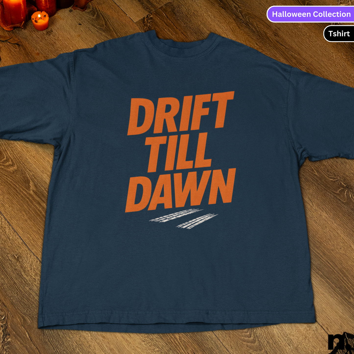 Navy blue t-shirt with 'DRIFT TILL DAWN' text in orange on a wooden surface.
