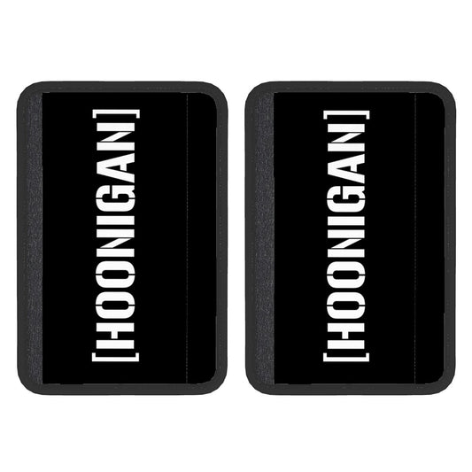 Two black neoprene seat belt cover pads with the white text 'HOONIGAN' on them, displayed against a white background.