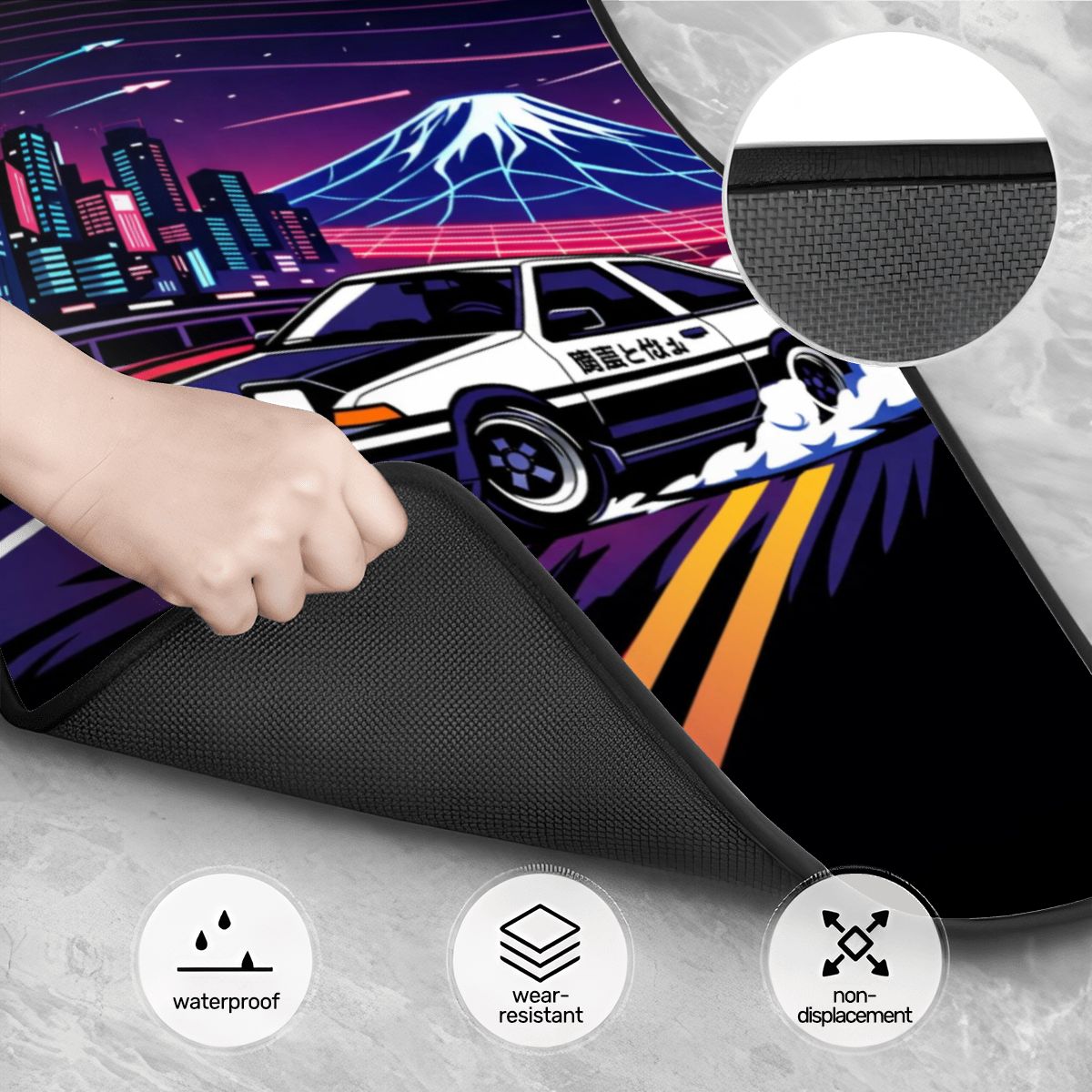Person holding a black mat with a colorful car and mountain design in the background