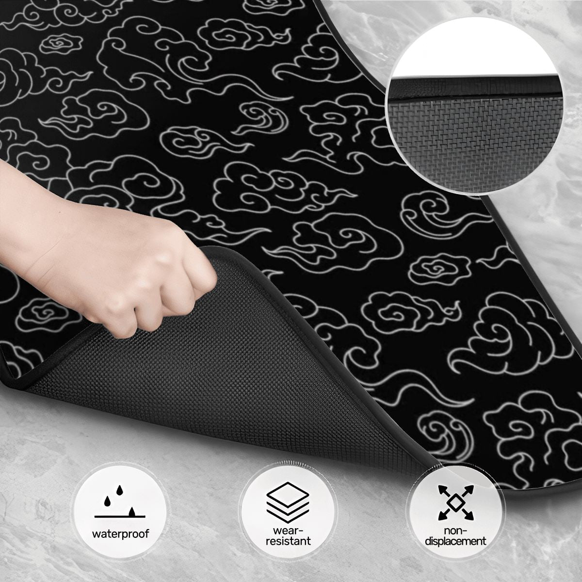 Black mat with cloud pattern being rolled out, showing features like waterproof, wear-resistant, and non-displacement on a gray background.