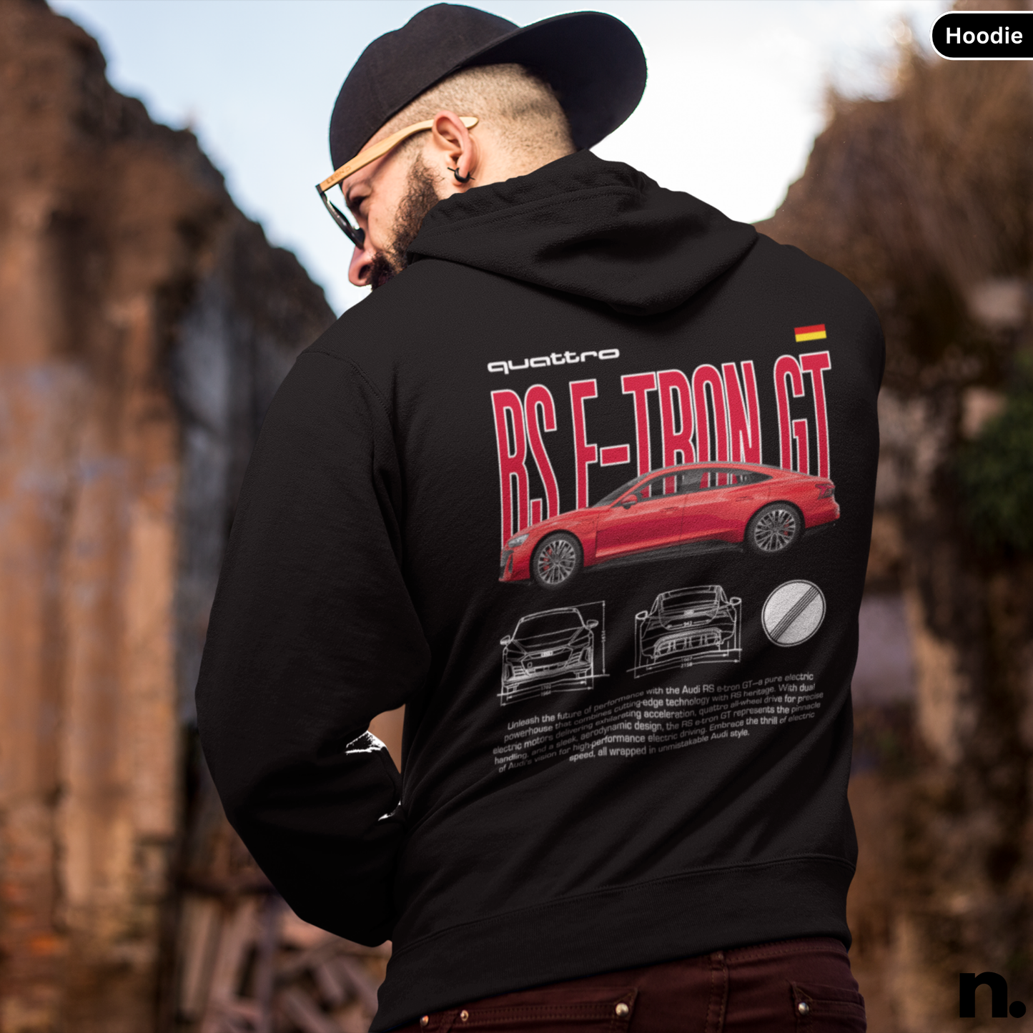 Person wearing a black hoodie with a red car design on the back, standing outdoors.