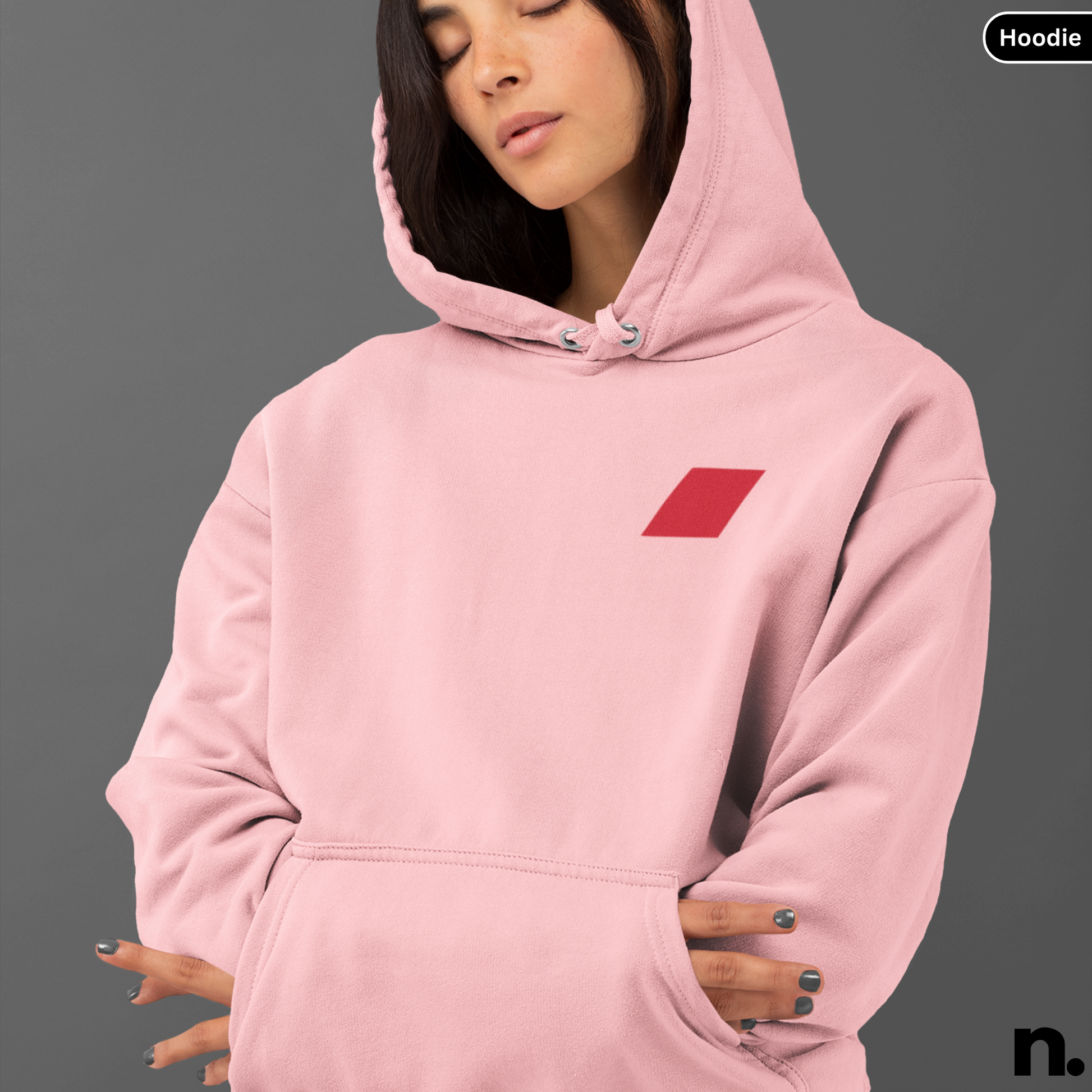 Person wearing a pink hoodie with a red logo on a gray background