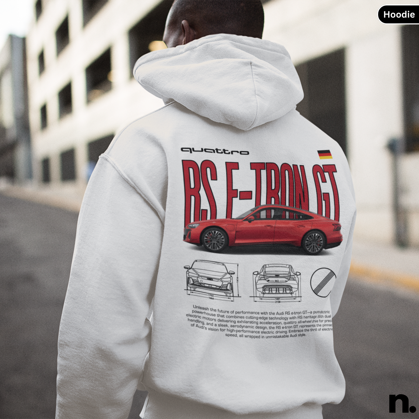 Person wearing a hoodie with a car design on the back, standing outdoors.