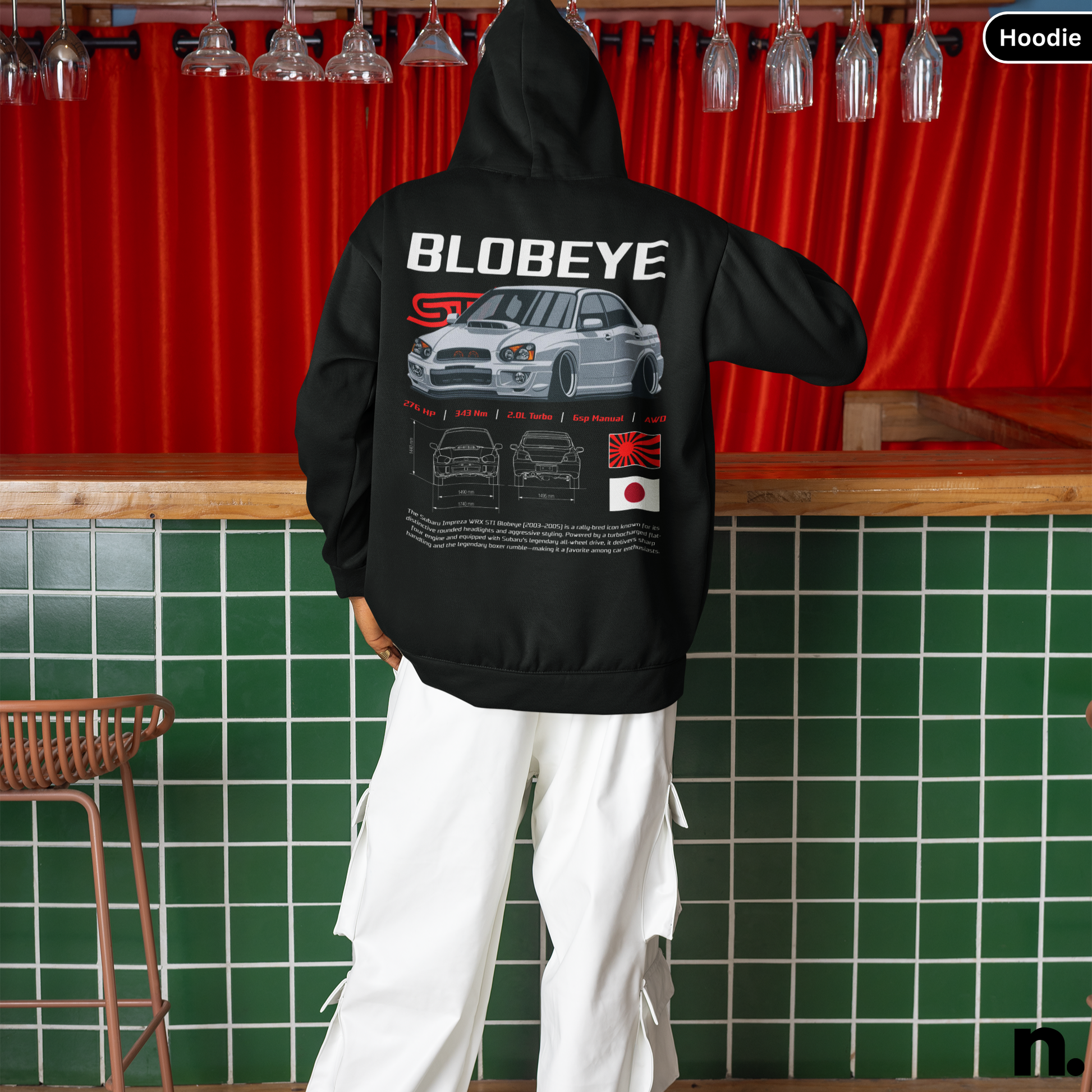 Person wearing a black hoodie with 'BLOBEYE' design in a bar setting