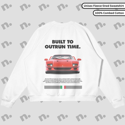Flat lay of a premium black sweatshirt featuring a bold Ferrari F40 graphic and the slogan "Built to Outrun Time", styled with casual urban wear on a neutral backdrop.