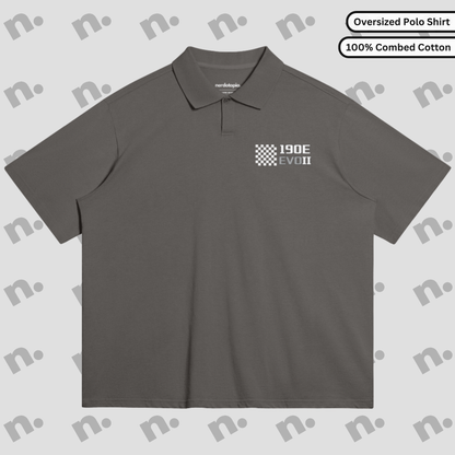 Flat lay of an oversized polo shirt featuring a subtle 190E Evo II inspired design, styled with motorsport and streetwear accessories on a neutral background.