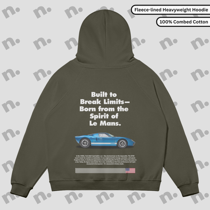 Flat lay of a fleece-lined premium hoodie featuring a bold GT40 inspired graphic, displayed with racing-style accessories on a neutral background.