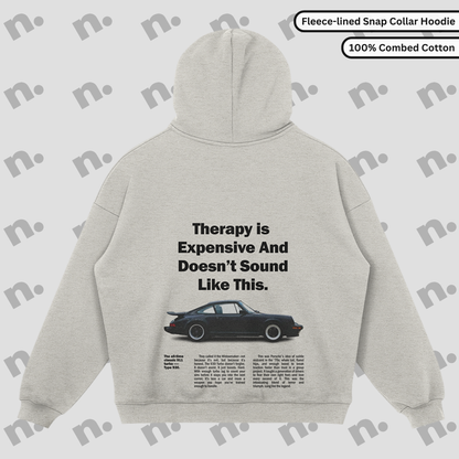 Flat lay of the 911 Therapy Snap Collar Fleece Premium Hoodie featuring a classic 911 graphic and 'Therapy is Expensive' slogan.