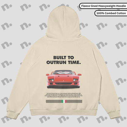 Flat lay of a premium black hoodie featuring a stylized Ferrari F40 graphic and the phrase "Built to Outrun Time", displayed with streetwear elements on a minimalist background.