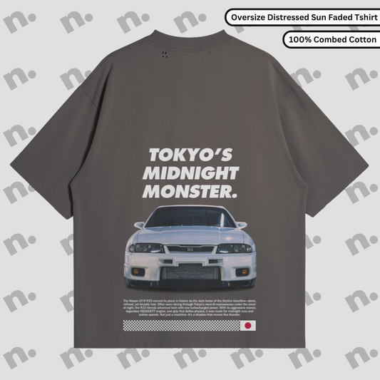 Flat lay of oversized washed-effect t-shirt featuring “TOKYO’S MIDNIGHT MONSTER.” GTR R33 design with distressed edges and tonal gradient, inspired by vintage Japanese street racing culture.