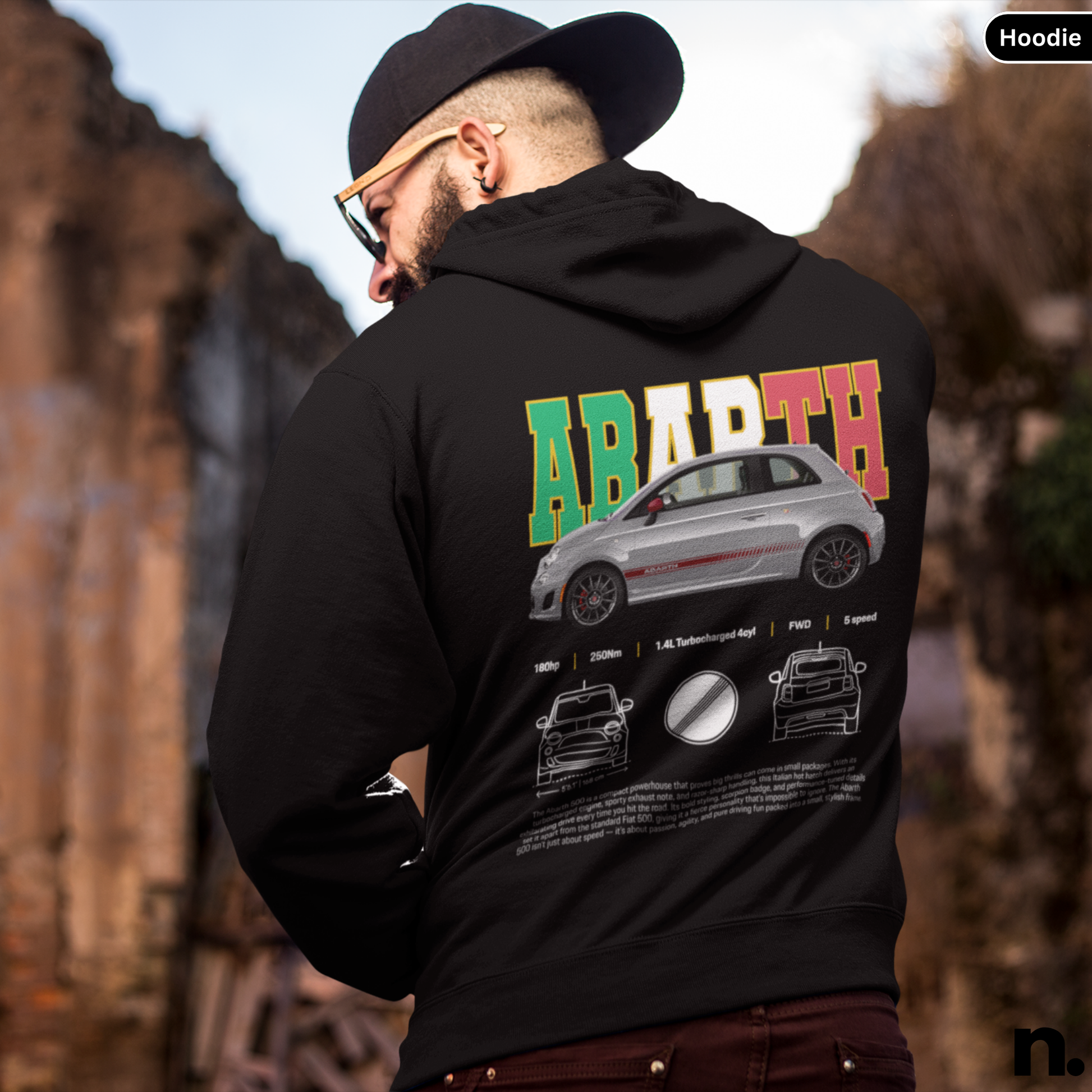 Person wearing a black hoodie with Abarth branding and car design on the back, standing outdoors.  Abarth 500 Poster Style Unisex Hoodie