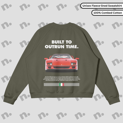 Flat lay of a premium black sweatshirt featuring a bold Ferrari F40 graphic and the slogan "Built to Outrun Time", styled with casual urban wear on a neutral backdrop.
