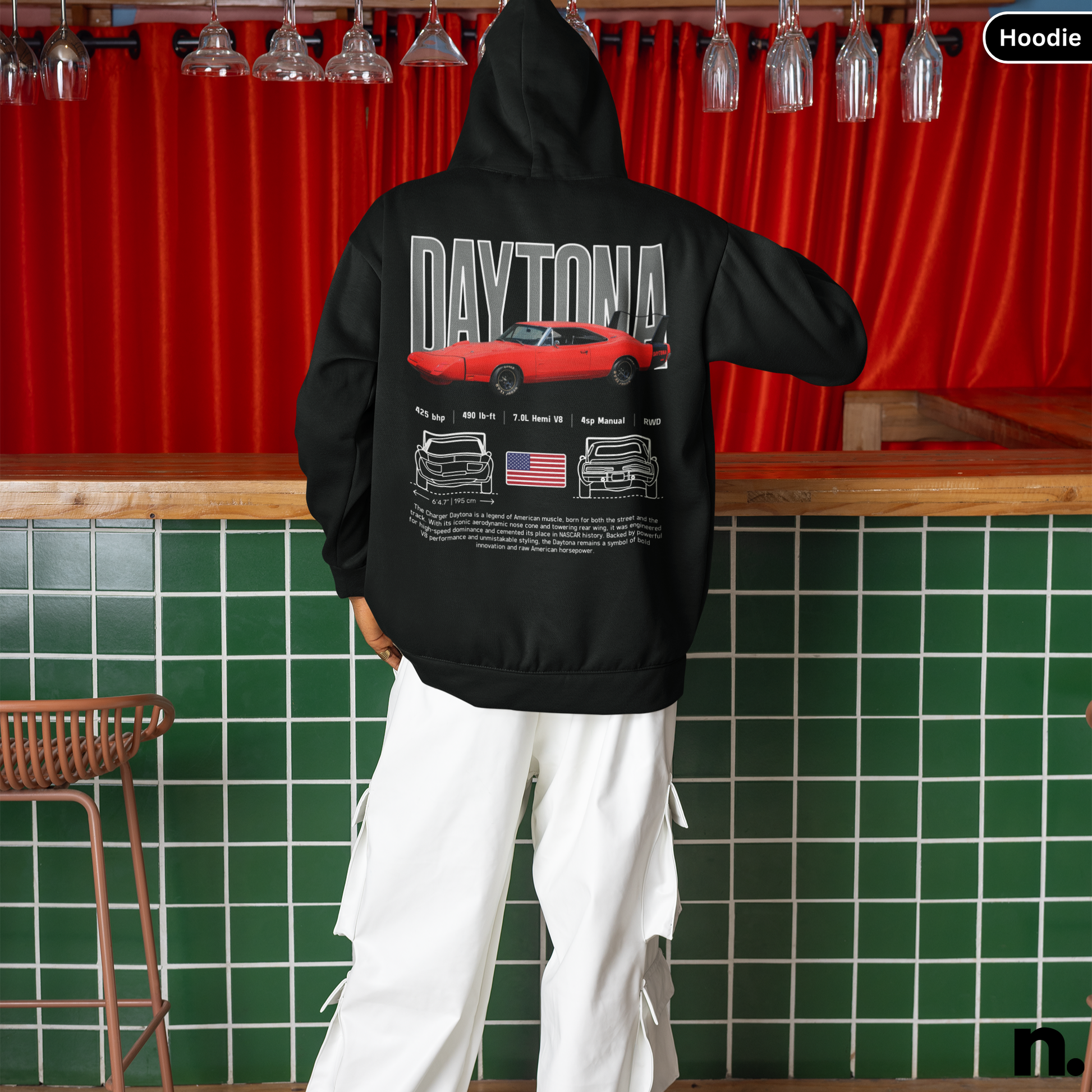 Person wearing a black hoodie with 'Daytona' design in a bar setting