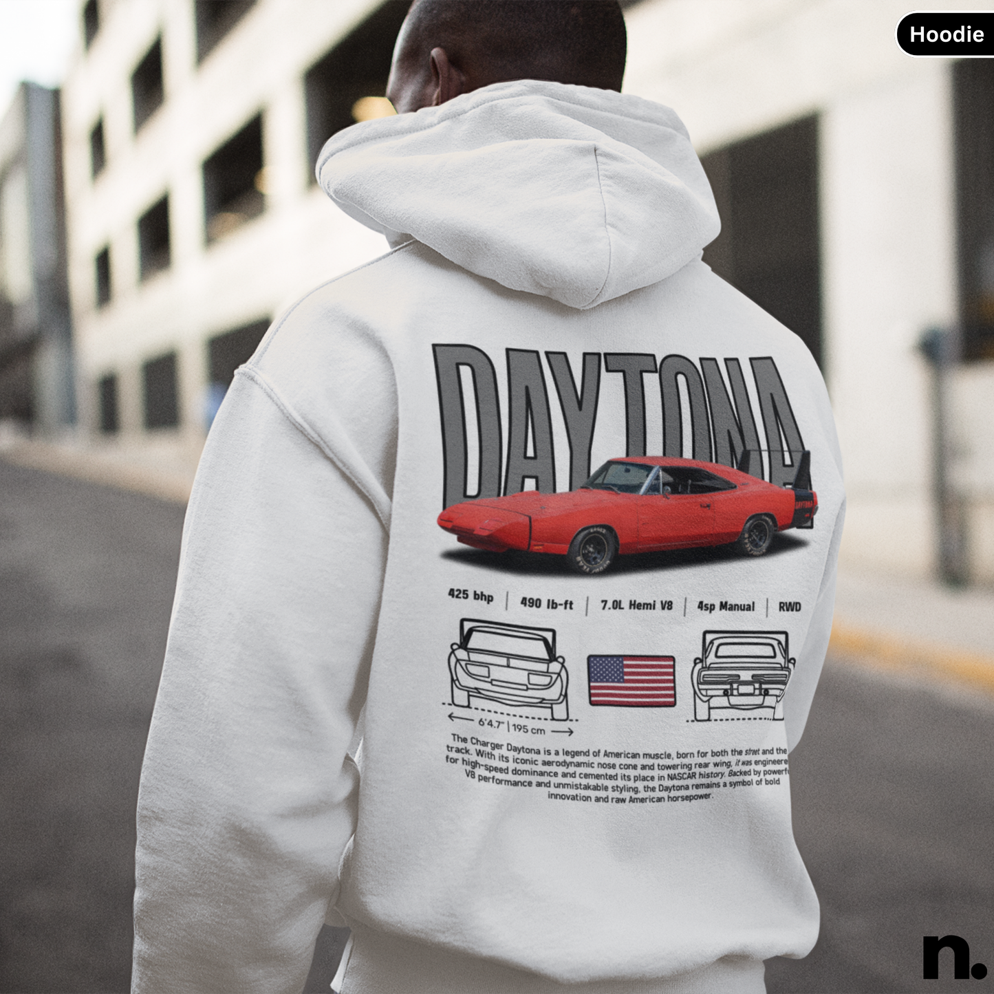 Person wearing a hoodie with 'Daytona' and car graphics on the back, standing in an urban setting.