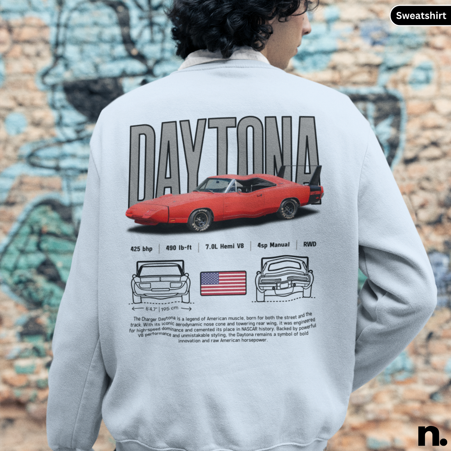 Person wearing a sweatshirt with a red car design and 'Daytona 4' text on the back, against a graffiti-covered wall.
