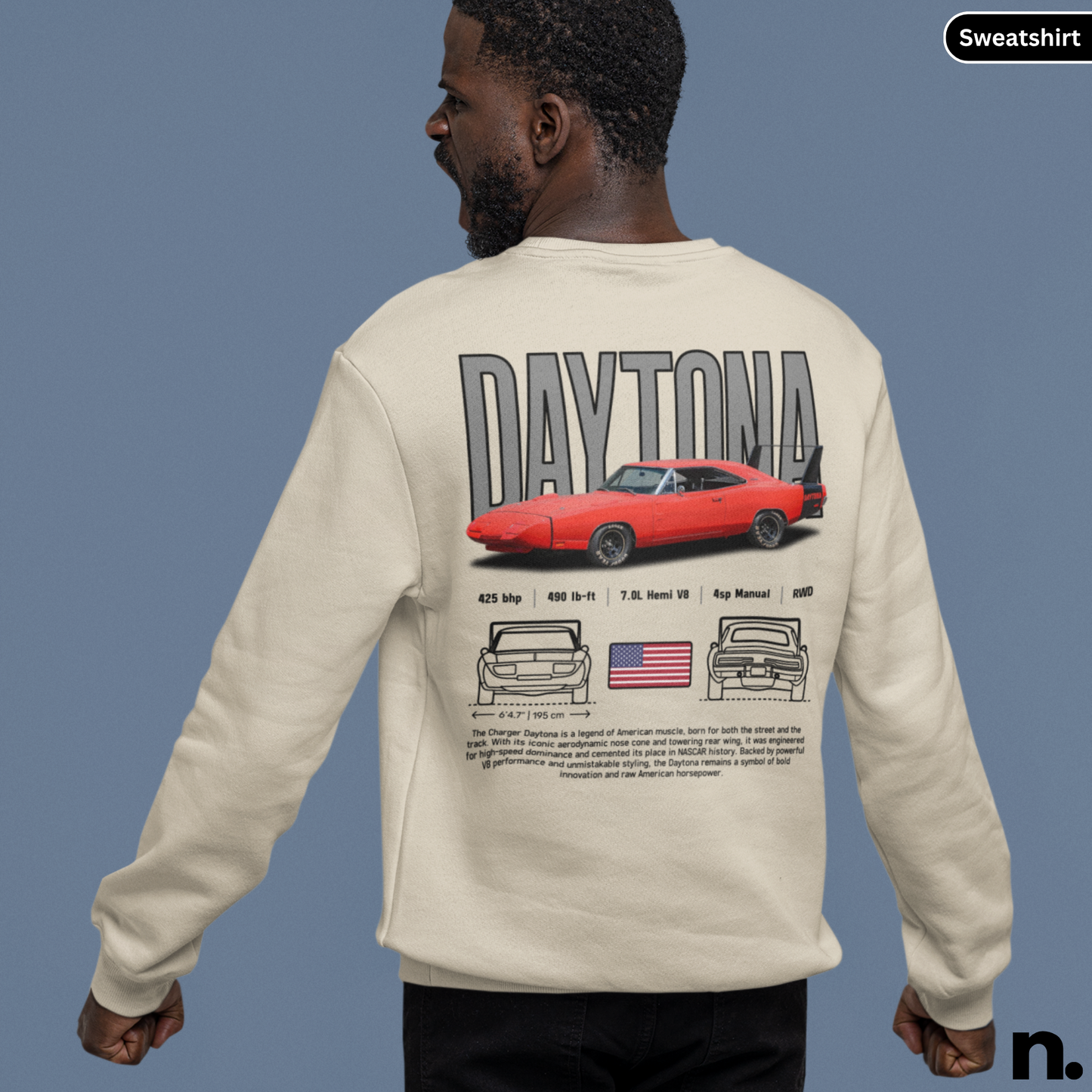 Person wearing a beige sweatshirt with 'Daytona' and car graphics on the back, against a gray background.