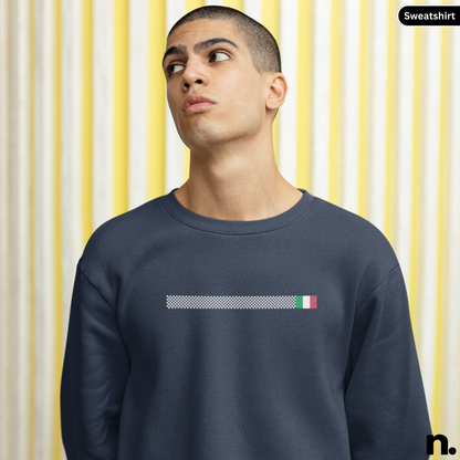 Man wearing a navy blue sweatshirt with a small flag design on a yellow and white striped background