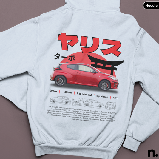 White hoodie with a red car graphic and Japanese text on the back, displayed on a brown background.