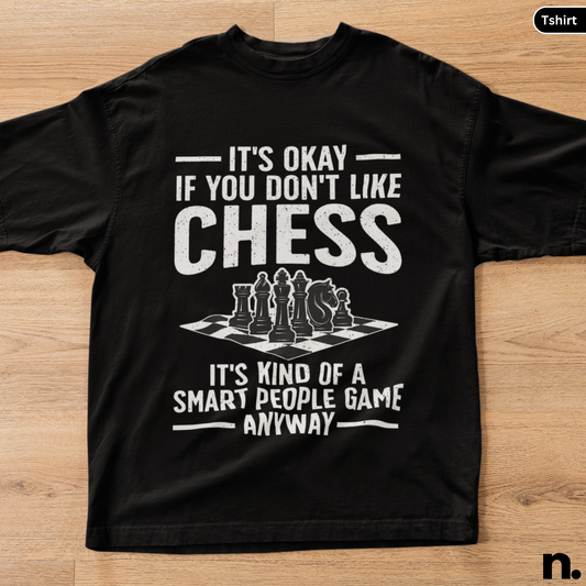 Black t-shirt with chess-themed text on a wooden surface