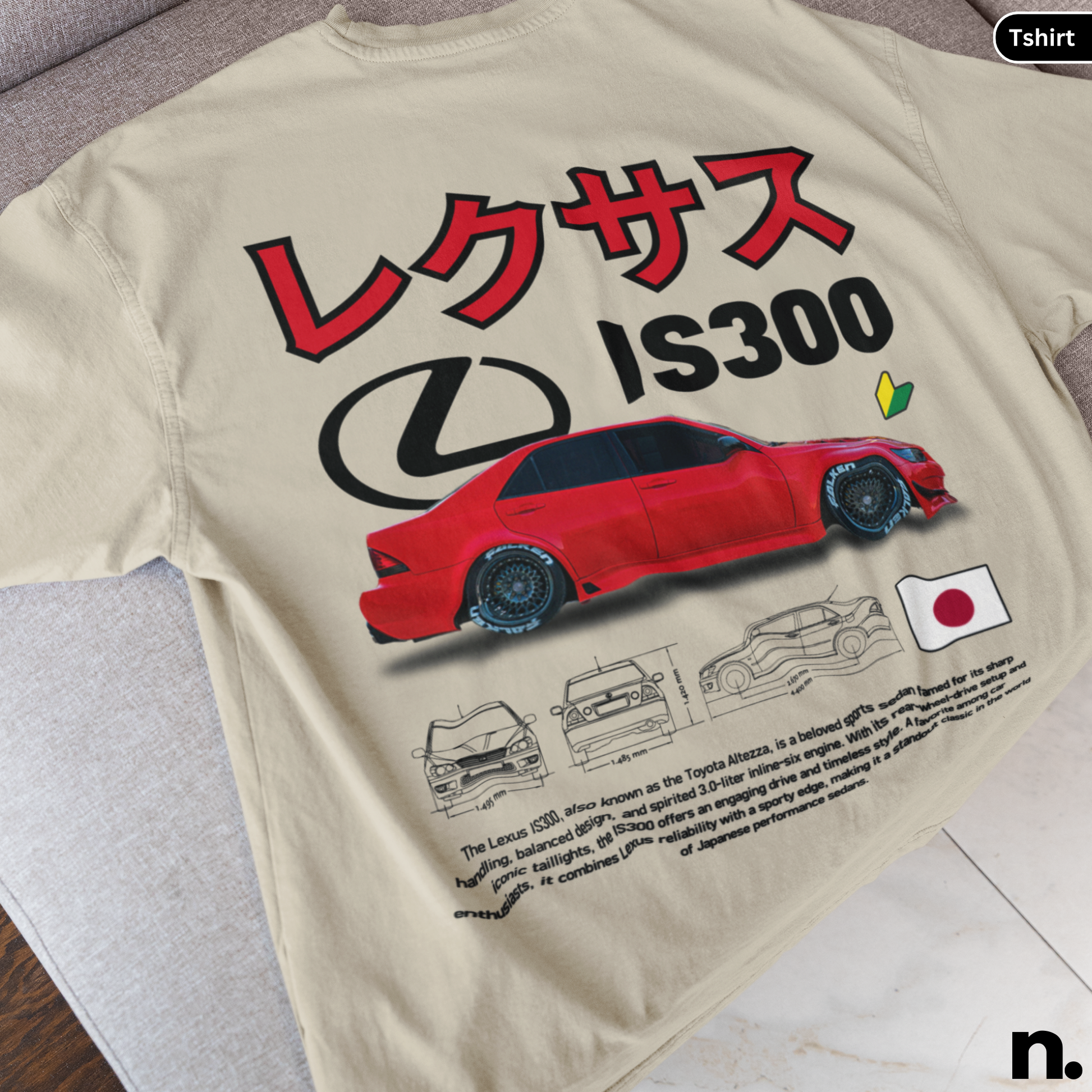 Beige t-shirt with red Lexus IS300 graphic and Japanese text on a wooden surface.
