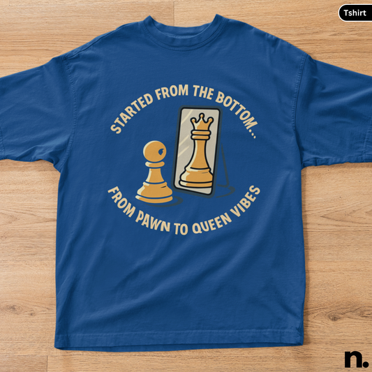 Blue t-shirt with chess-themed graphic and text on a wooden surface