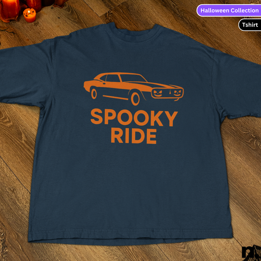 Navy blue t-shirt with orange graphic and 'Spooky Ride' text on a wooden surface.