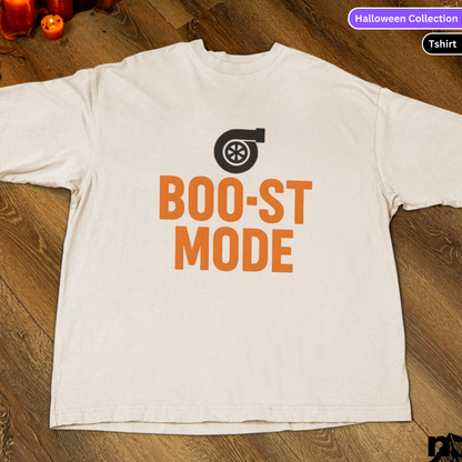White t-shirt with 'BOO-ST MODE' text and turbo graphic on a wooden surface.