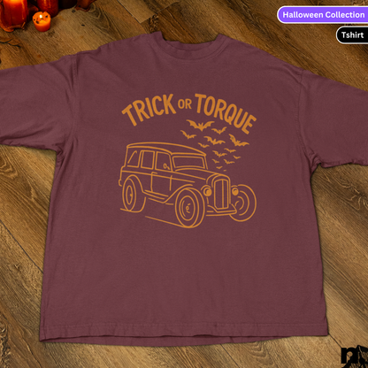 Maroon t-shirt with 'Trick or Torque' design on a wooden surface