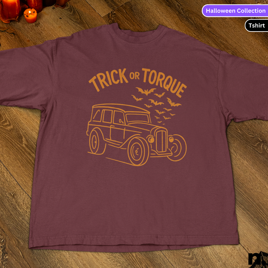 Maroon t-shirt with 'Trick or Torque' design on a wooden surface