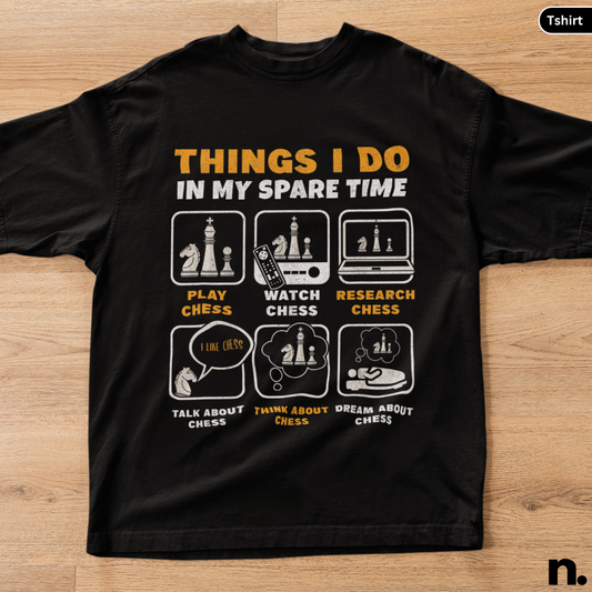 Black t-shirt with chess-themed graphics and text on a wooden surface