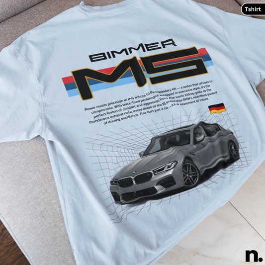 White t-shirt with BMW M5 graphic and text on a wooden surface