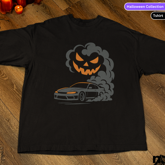 Black t-shirt with a car and pumpkin graphic on a wooden surface, labeled 'Halloween Collection'.