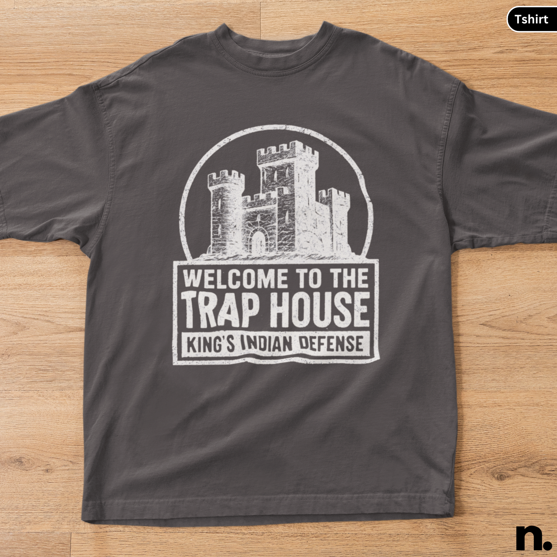 Black t-shirt with a castle graphic and text on a wooden surface