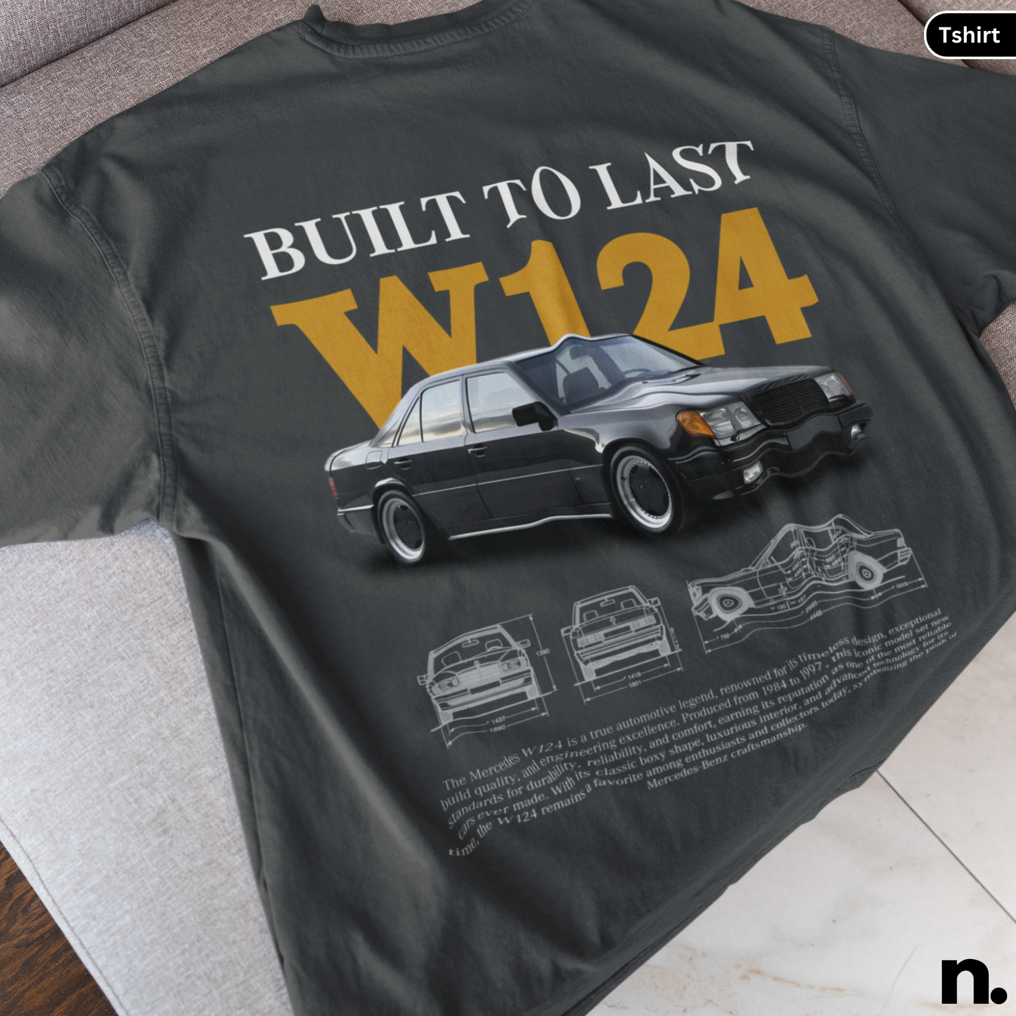 Black t-shirt with car design and text 'Built to Last W124' on a surface.