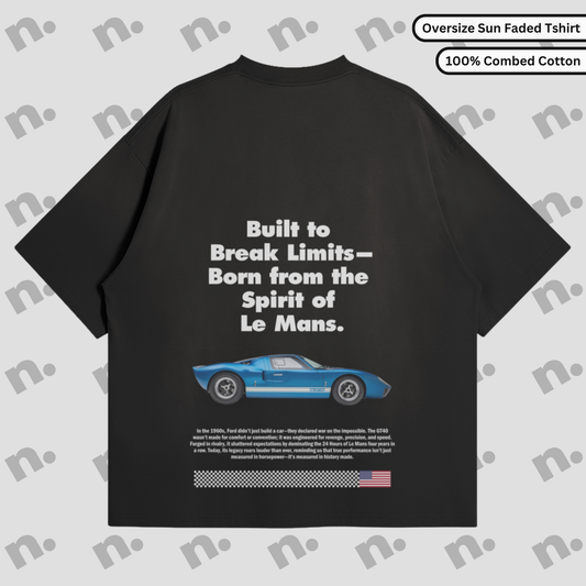 Flat lay of a premium T-shirt featuring a bold GT40 Le Mans poster-style graphic, arranged with vintage racing accessories on a clean background.