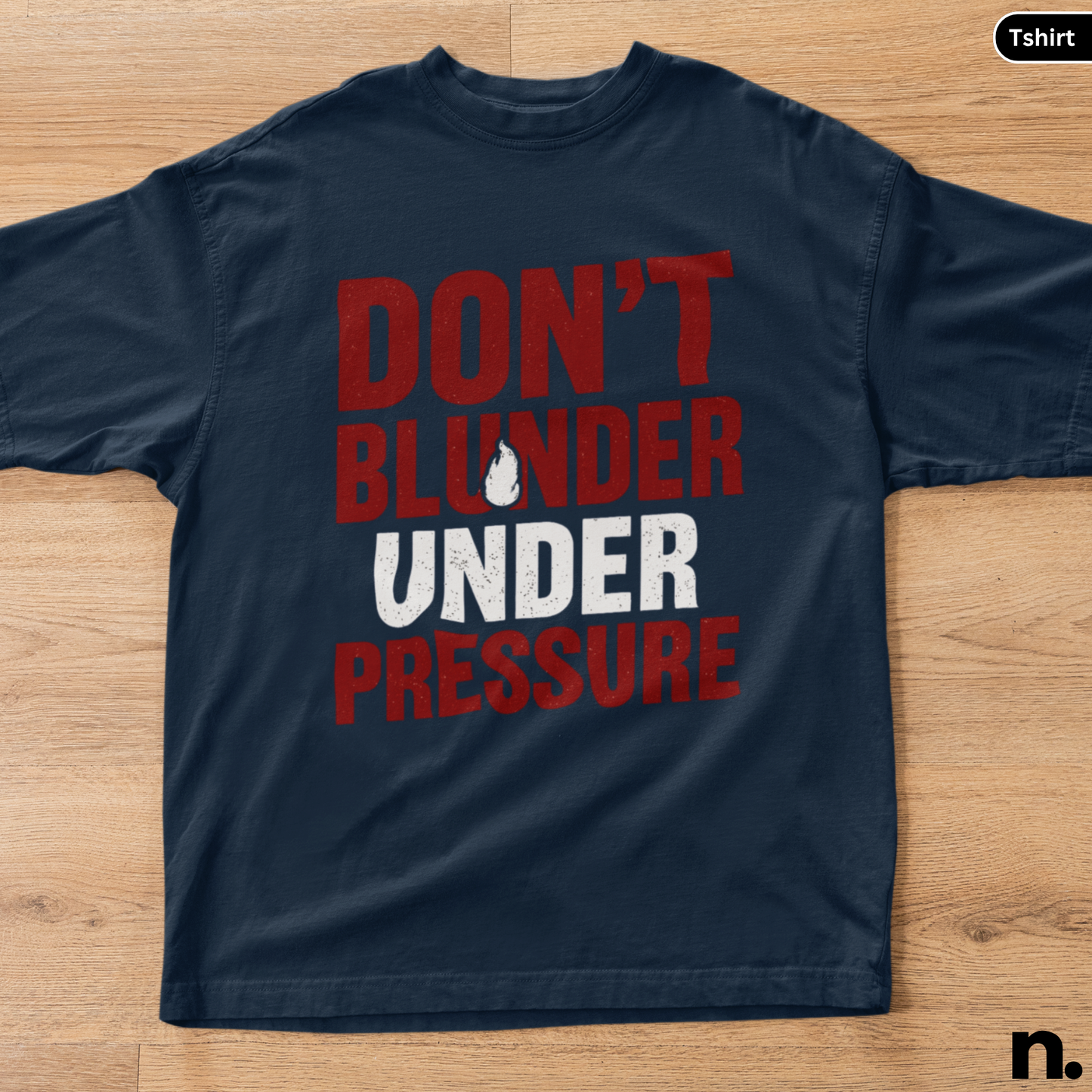 Navy blue t-shirt with red and white text on a wooden surface