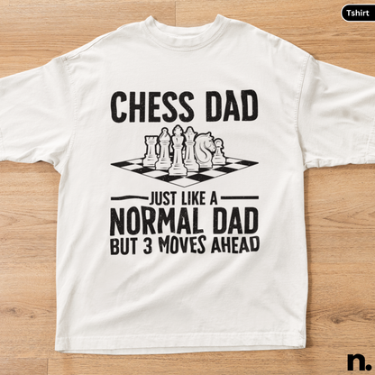 White t-shirt with chess-themed text on a wooden surface