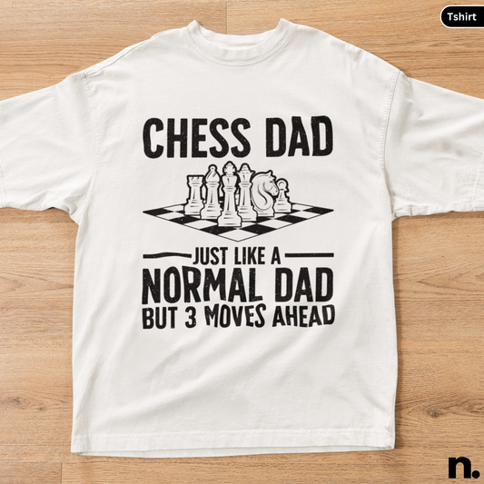 White t-shirt with chess-themed text on a wooden surface