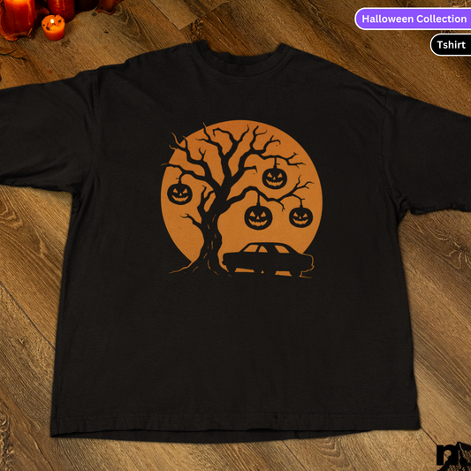Black t-shirt with Halloween-themed design featuring a tree, pumpkins, and a car on a wooden surface.
