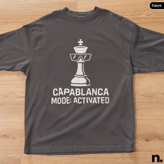 Gray t-shirt with a chess piece graphic and text on a wooden surface