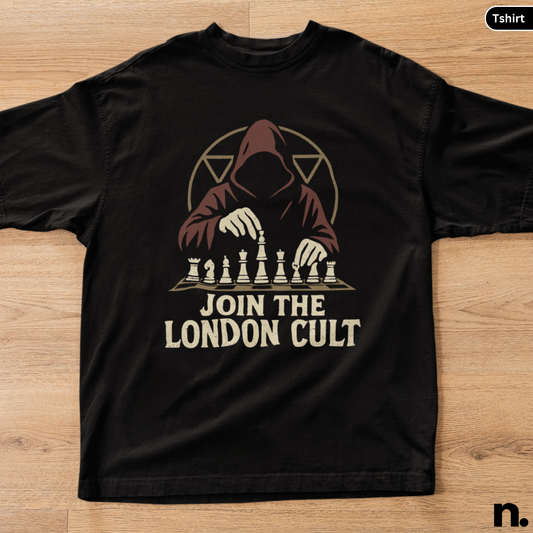 Black t-shirt with a graphic design of a hooded figure playing chess and text 'Join the London Cult' on a wooden surface.