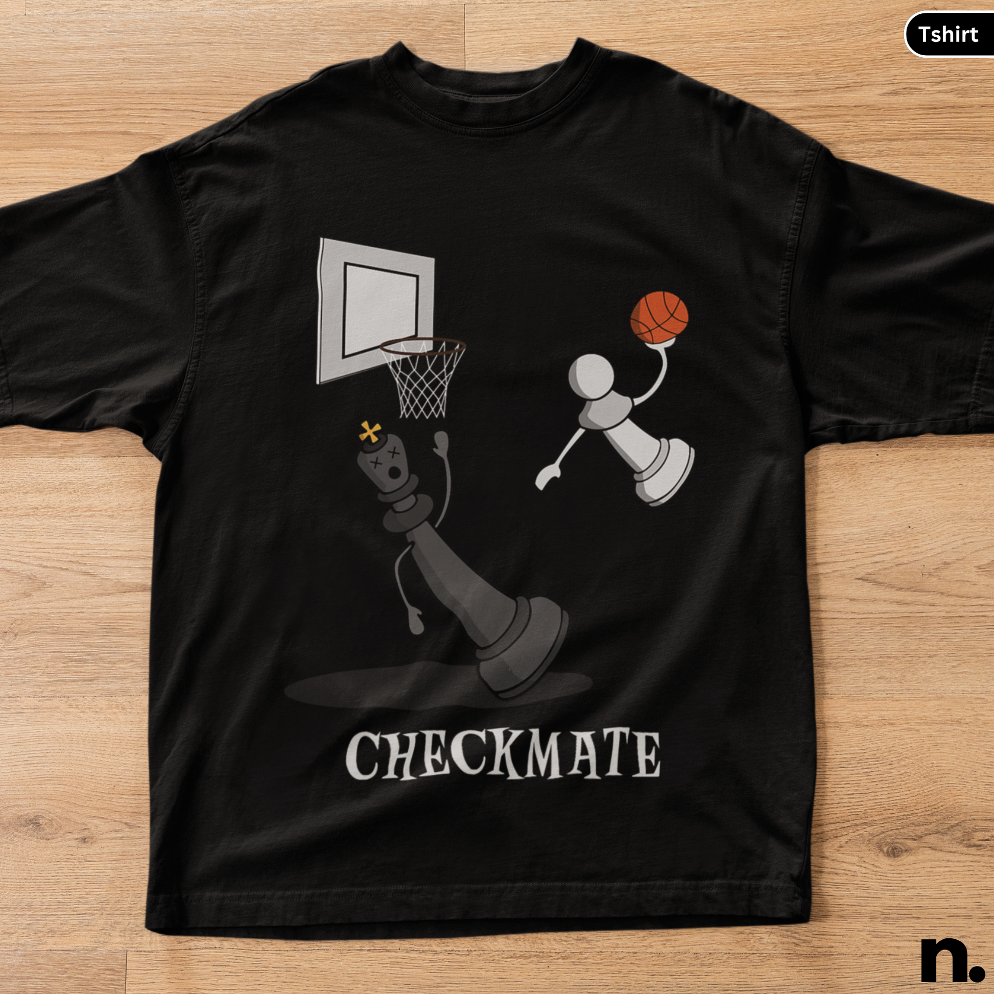 Black t-shirt with a graphic design of a chess piece playing basketball and the word 'CHECKMATE' on a wooden surface.