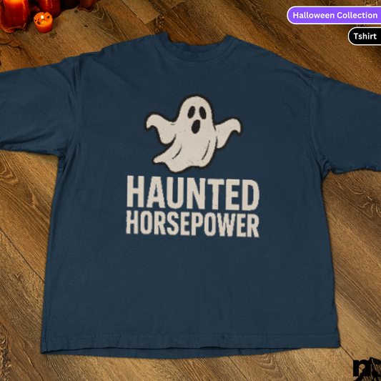 Navy blue t-shirt with ghost graphic and 'Haunted Horsepower' text on a wooden surface.