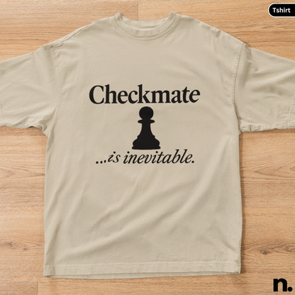 Beige t-shirt with a black chess piece and text on a wooden surface