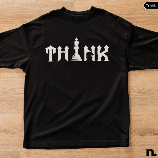 Black t-shirt with 'THINK' and chess piece design on a wooden surface
