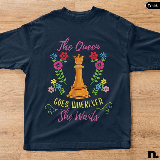Navy blue t-shirt with a chess queen design and floral elements on a wooden surface