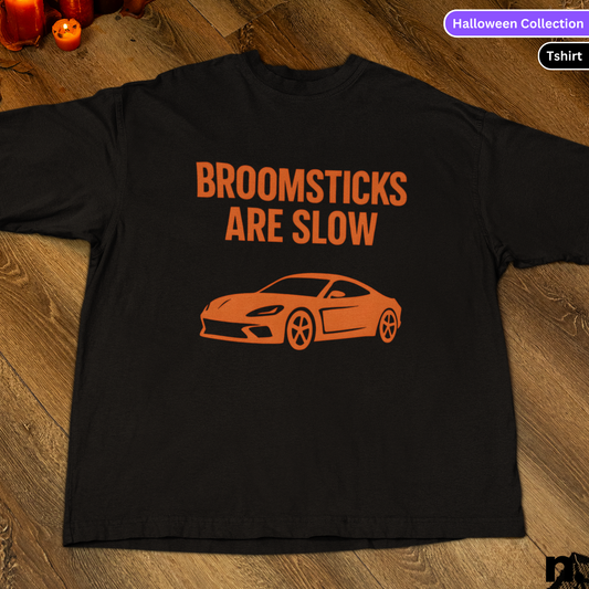 Black t-shirt with orange text and car graphic on a wooden surface, labeled 'Halloween Collection'.