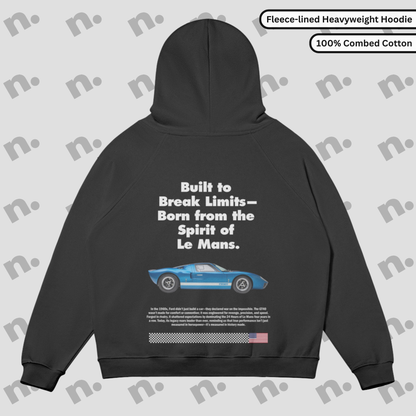 Flat lay of a fleece-lined premium hoodie featuring a bold GT40 inspired graphic, displayed with racing-style accessories on a neutral background.